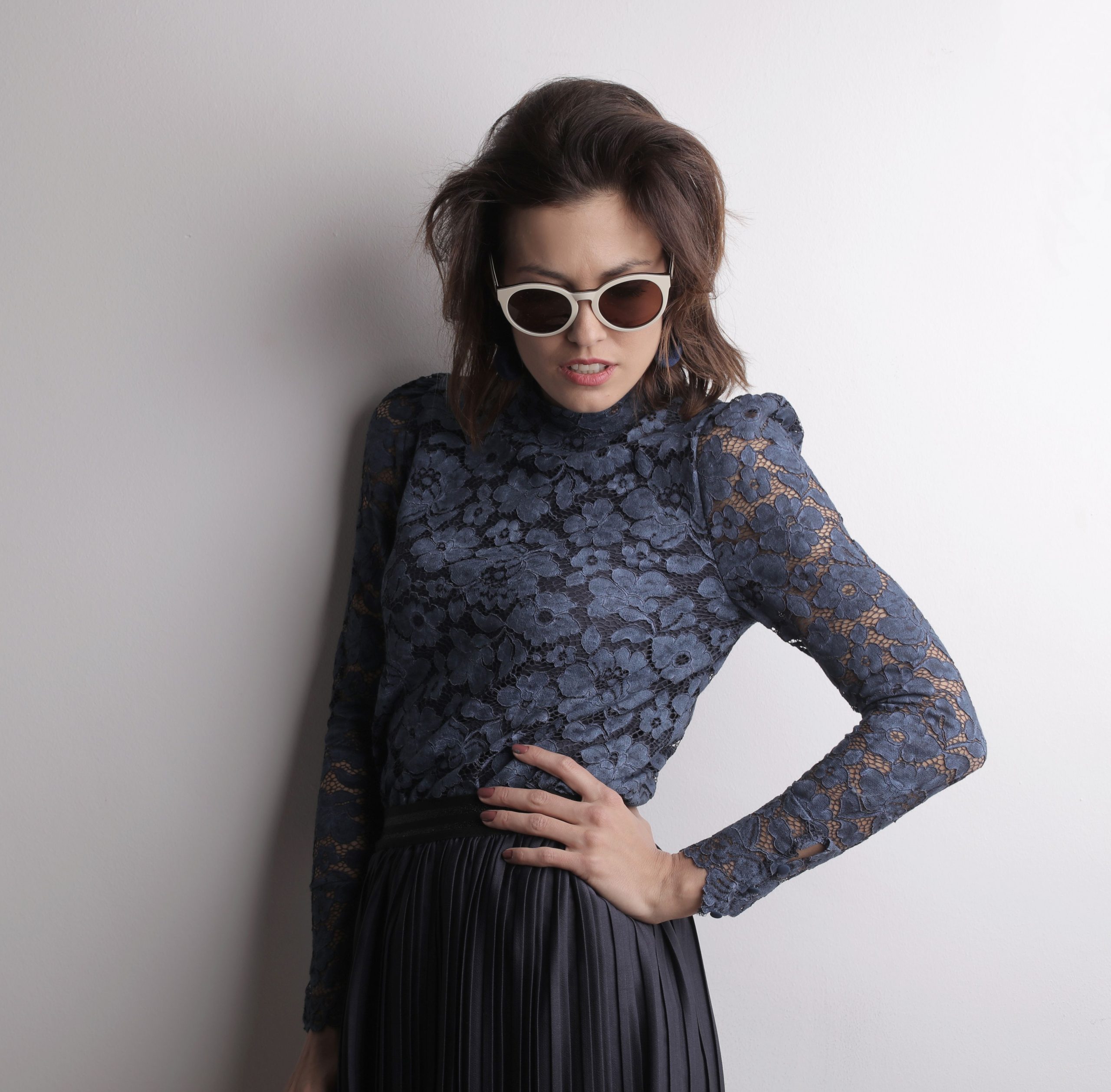 Femme chic en top dentelle pose lunettes soleil