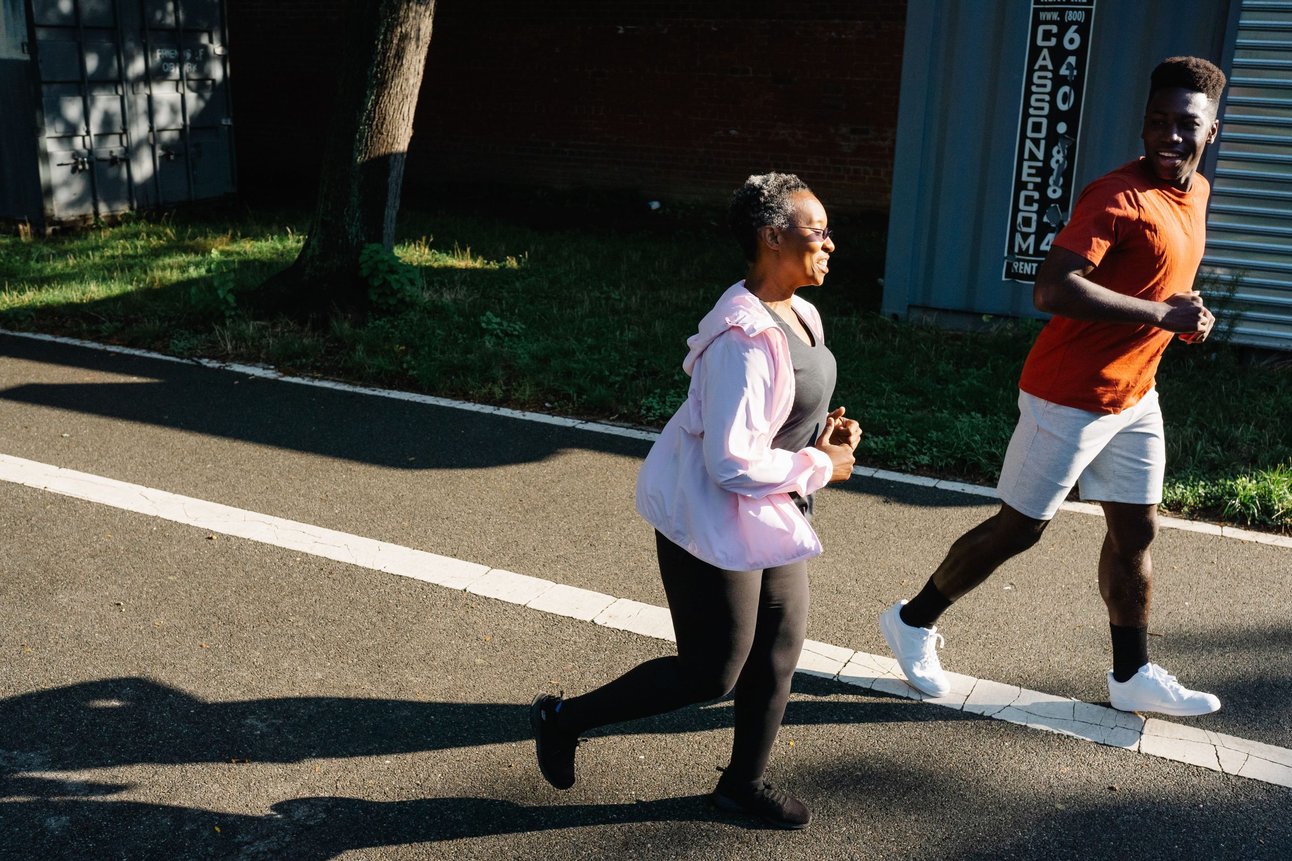 Deux adultes souriant pendant leur séance de jogging