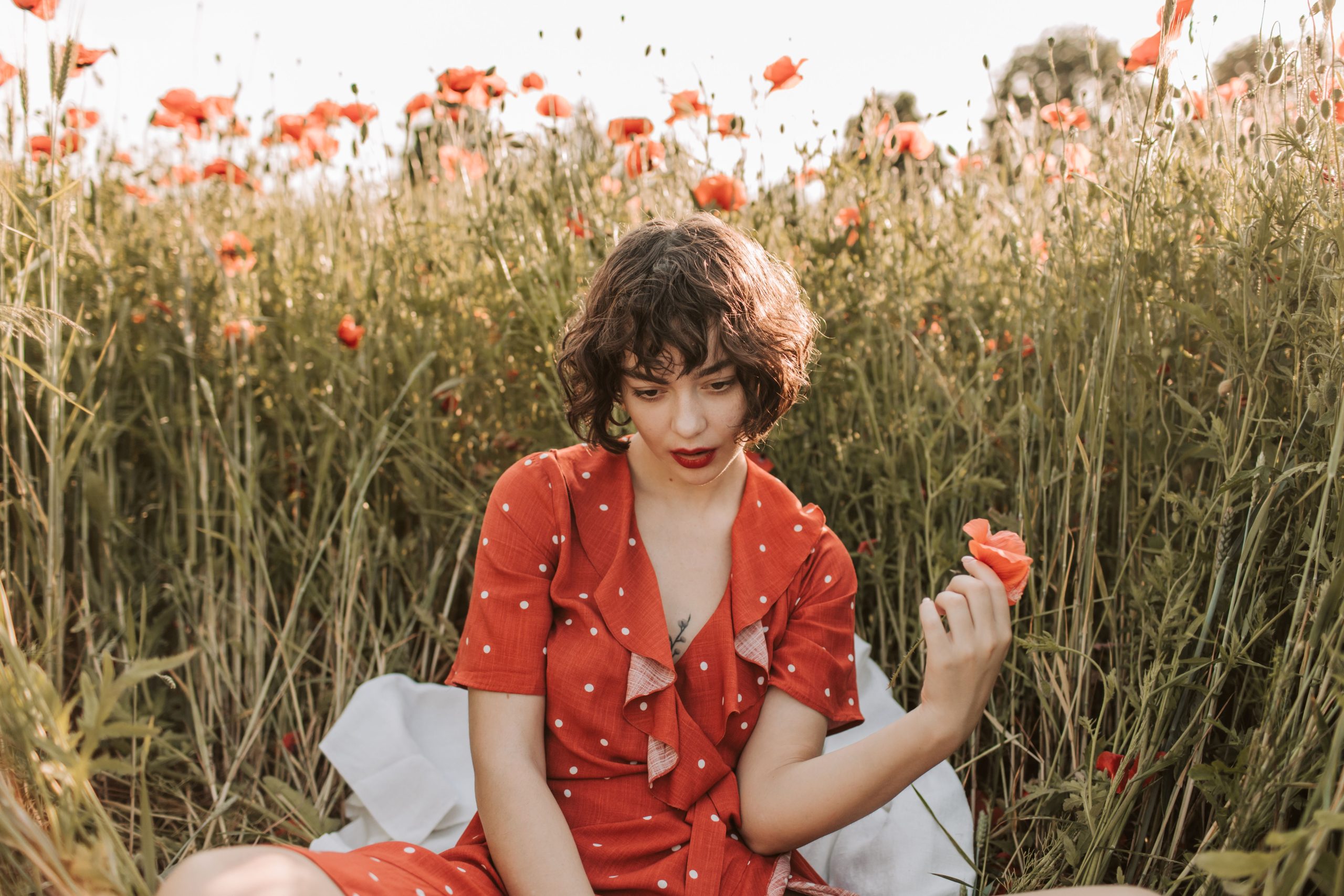 Femme en robe rouge dans un champ de coquelicots
