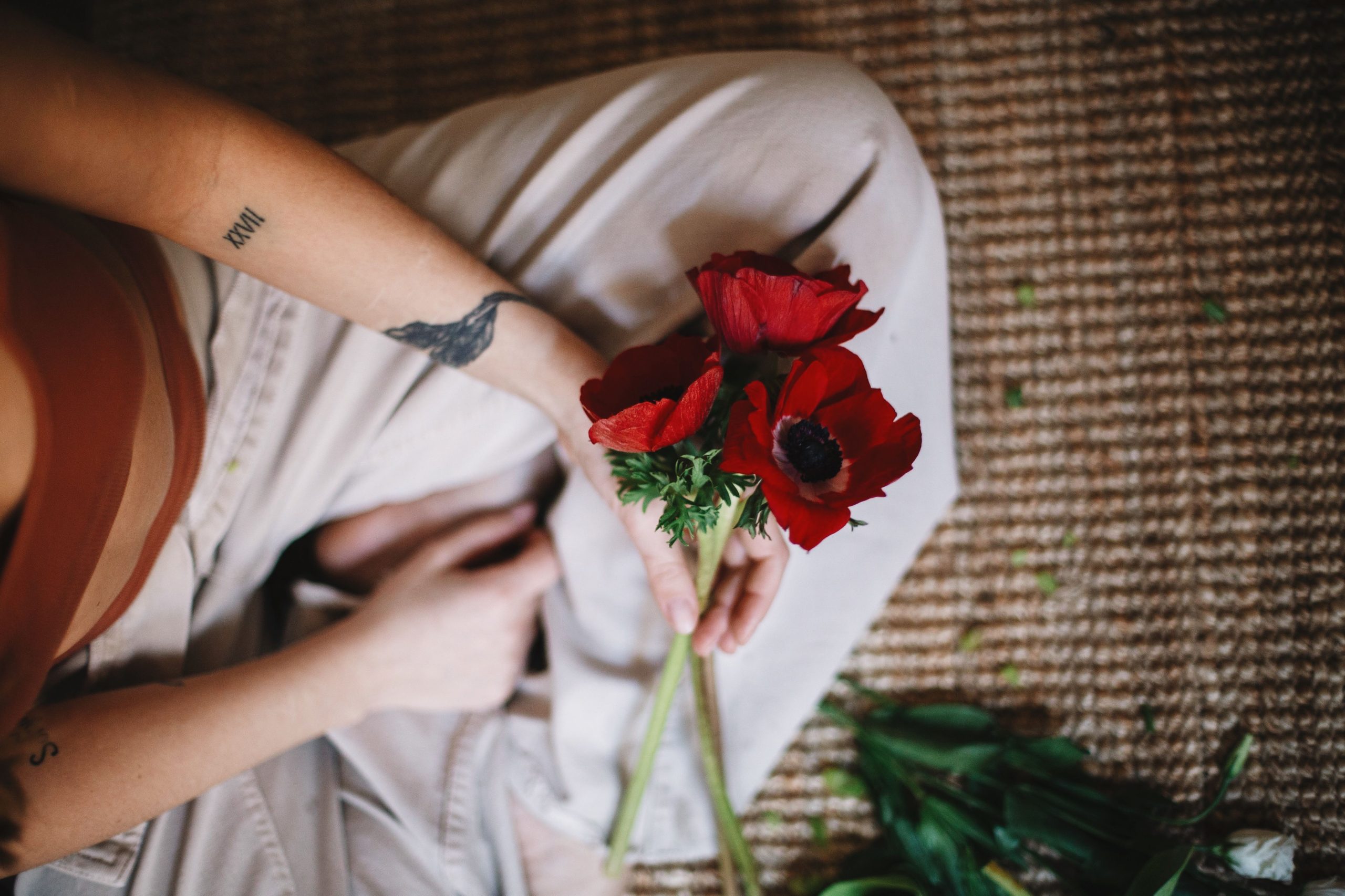 Personne tenant un bouquet de coquelicots rouges