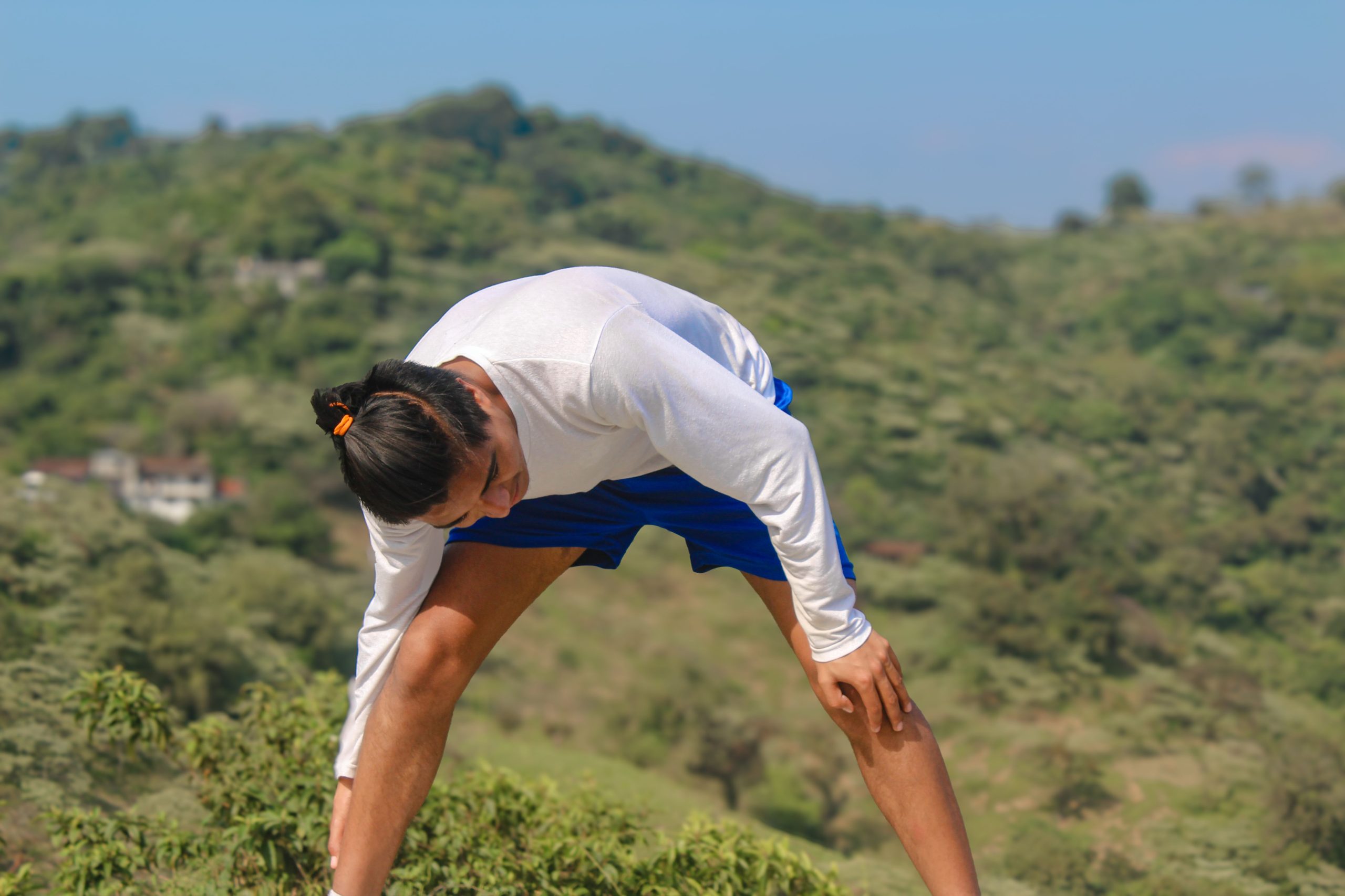Homme pratiquant le yoga en montagne pour son bien-être
