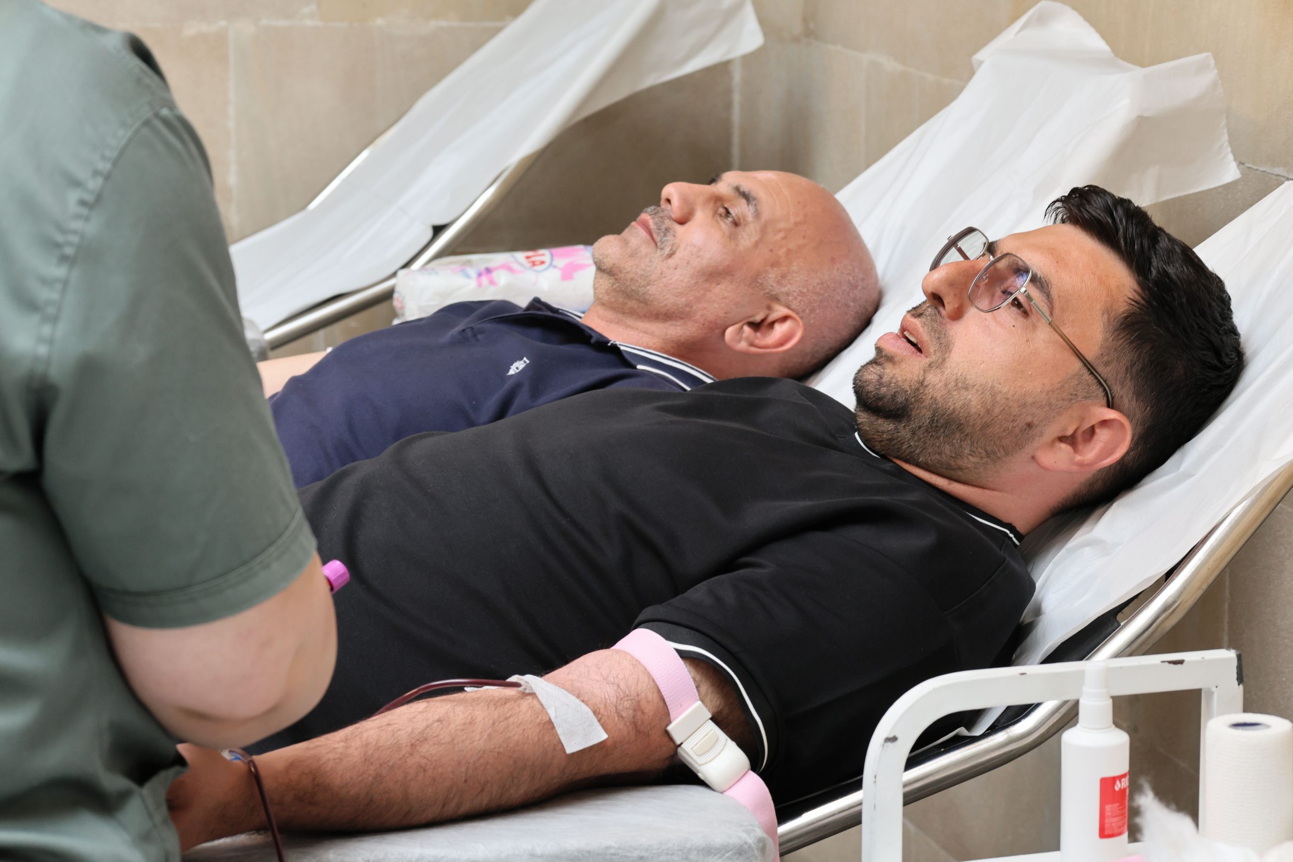Deux hommes donnent du sang à la clinique