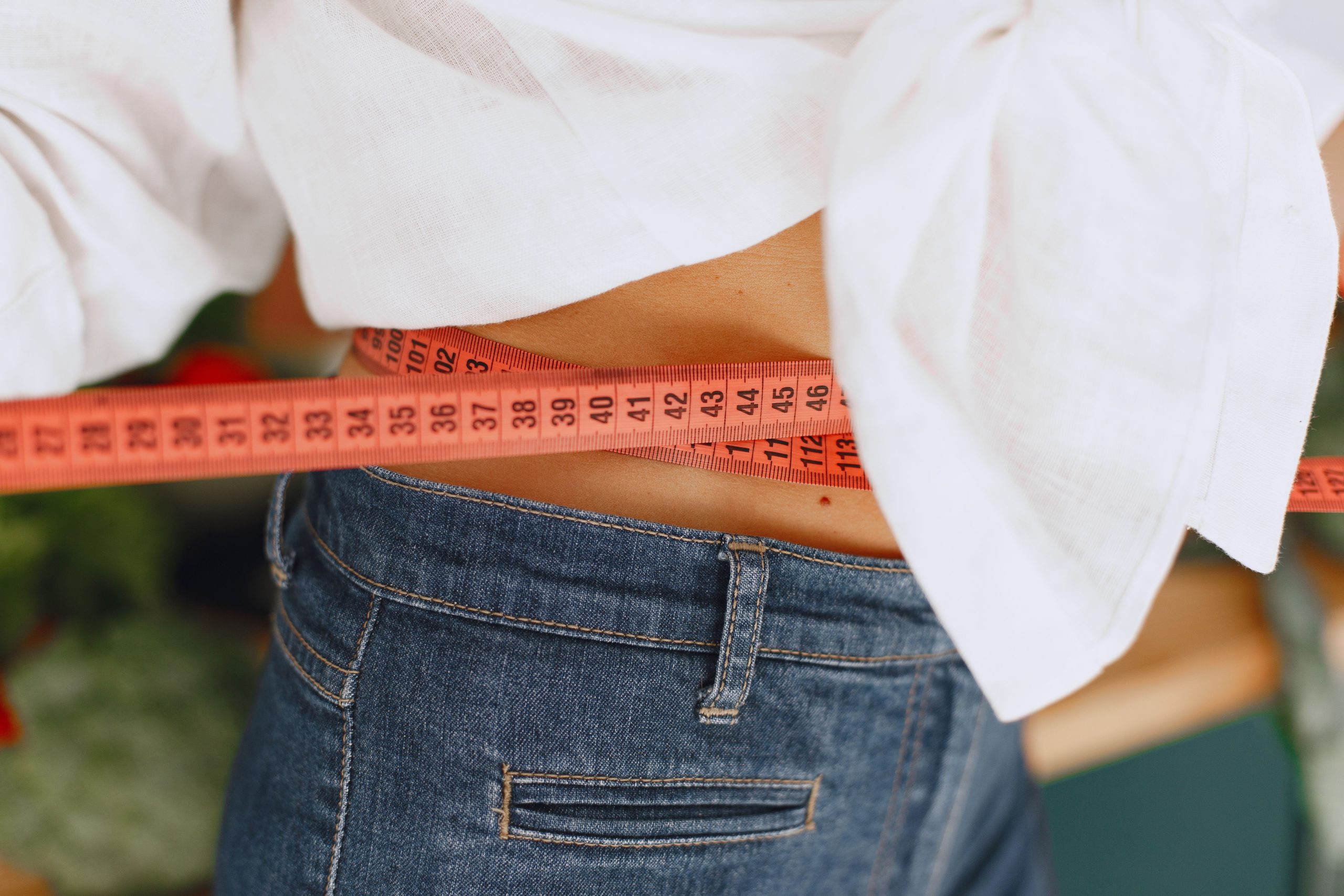 Femme mesure sa taille pour objectifs fitness santé