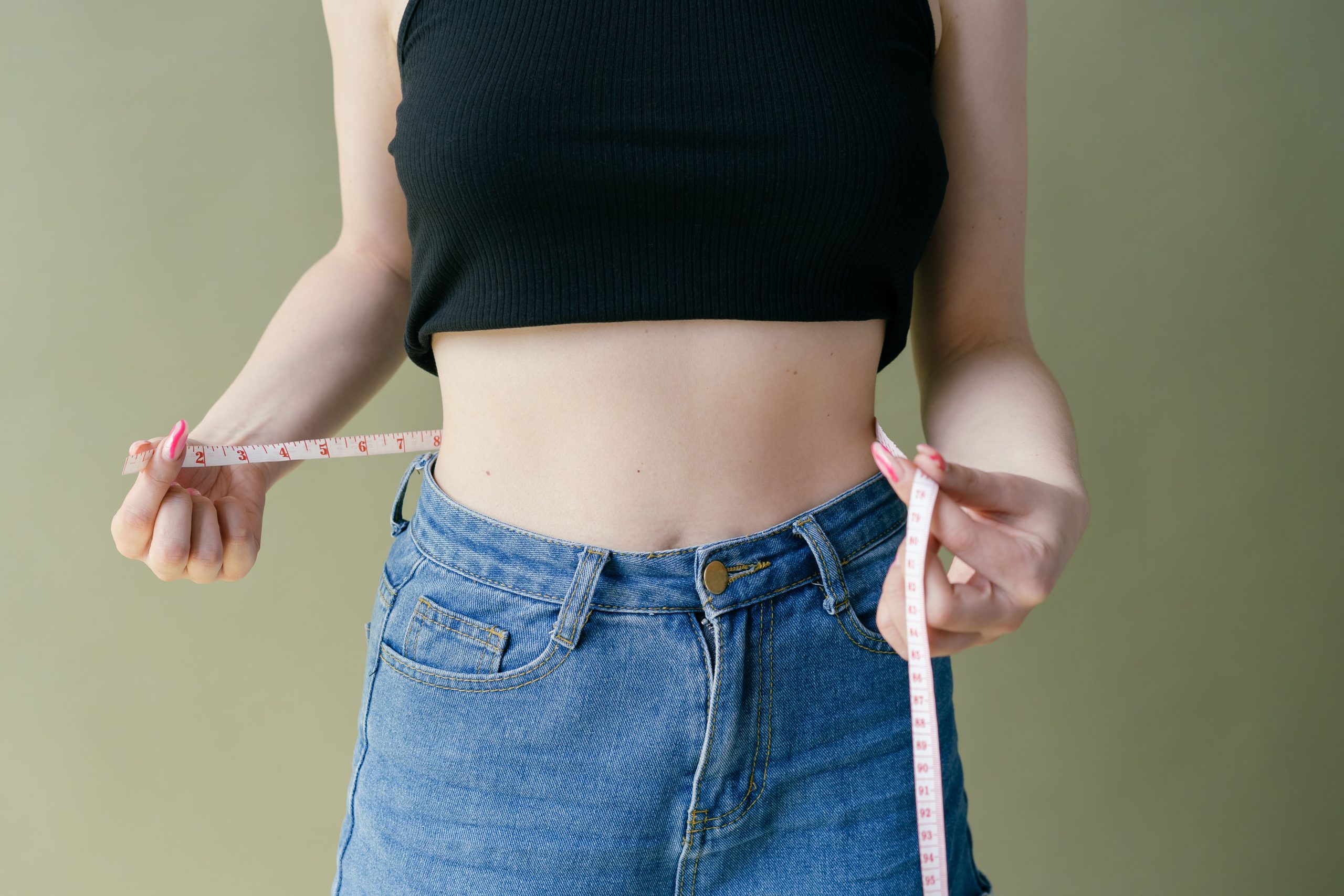 Femme mesure taille avec mètre ruban