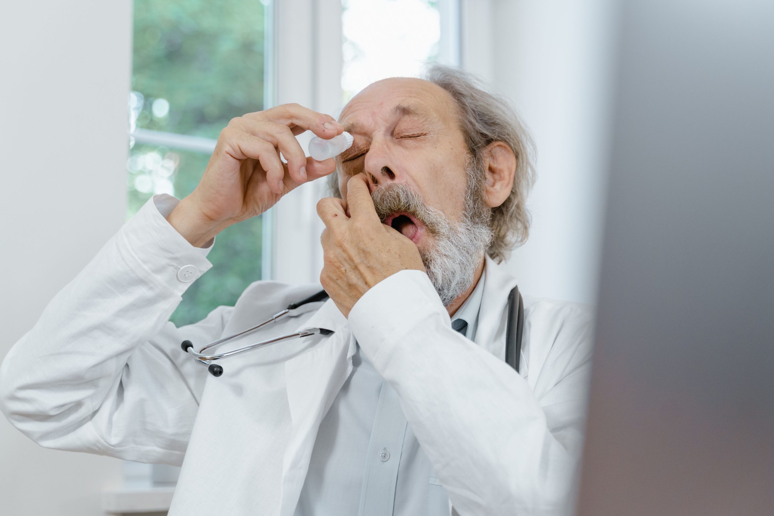 Médecin senior appliquant des gouttes oculaires