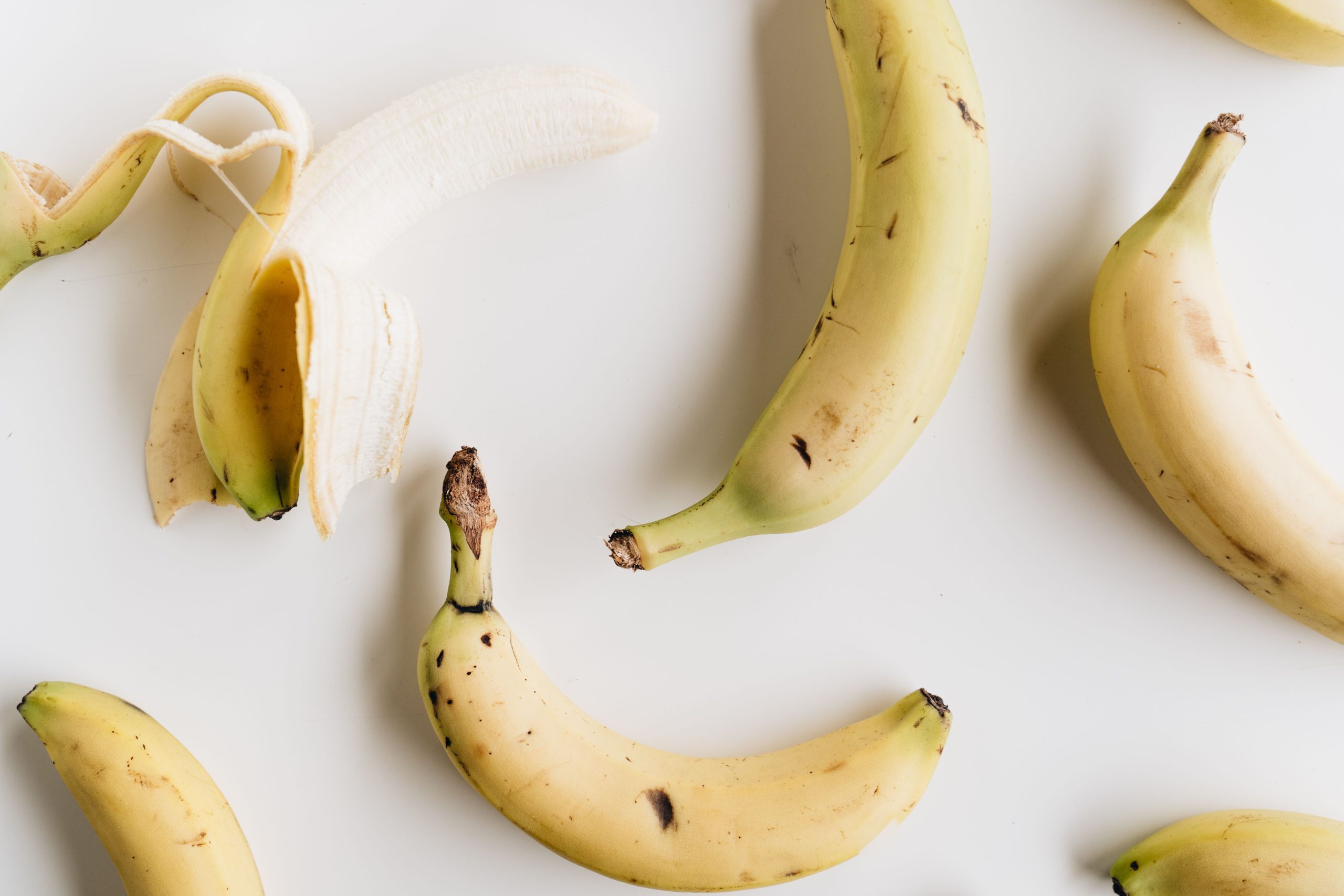 Bananes posées sur fond blanc minimaliste