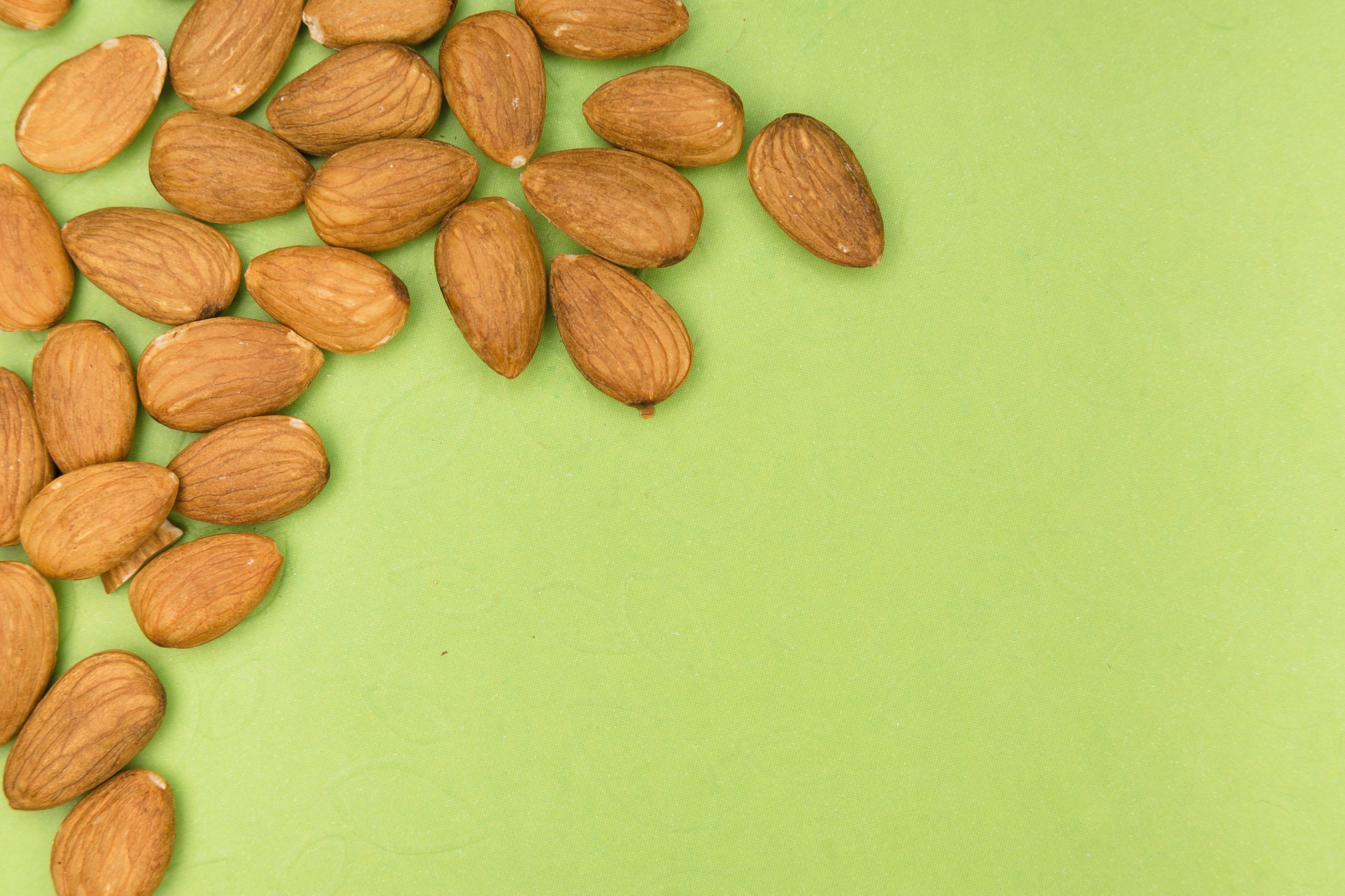 Amandes disposées sur fond vert