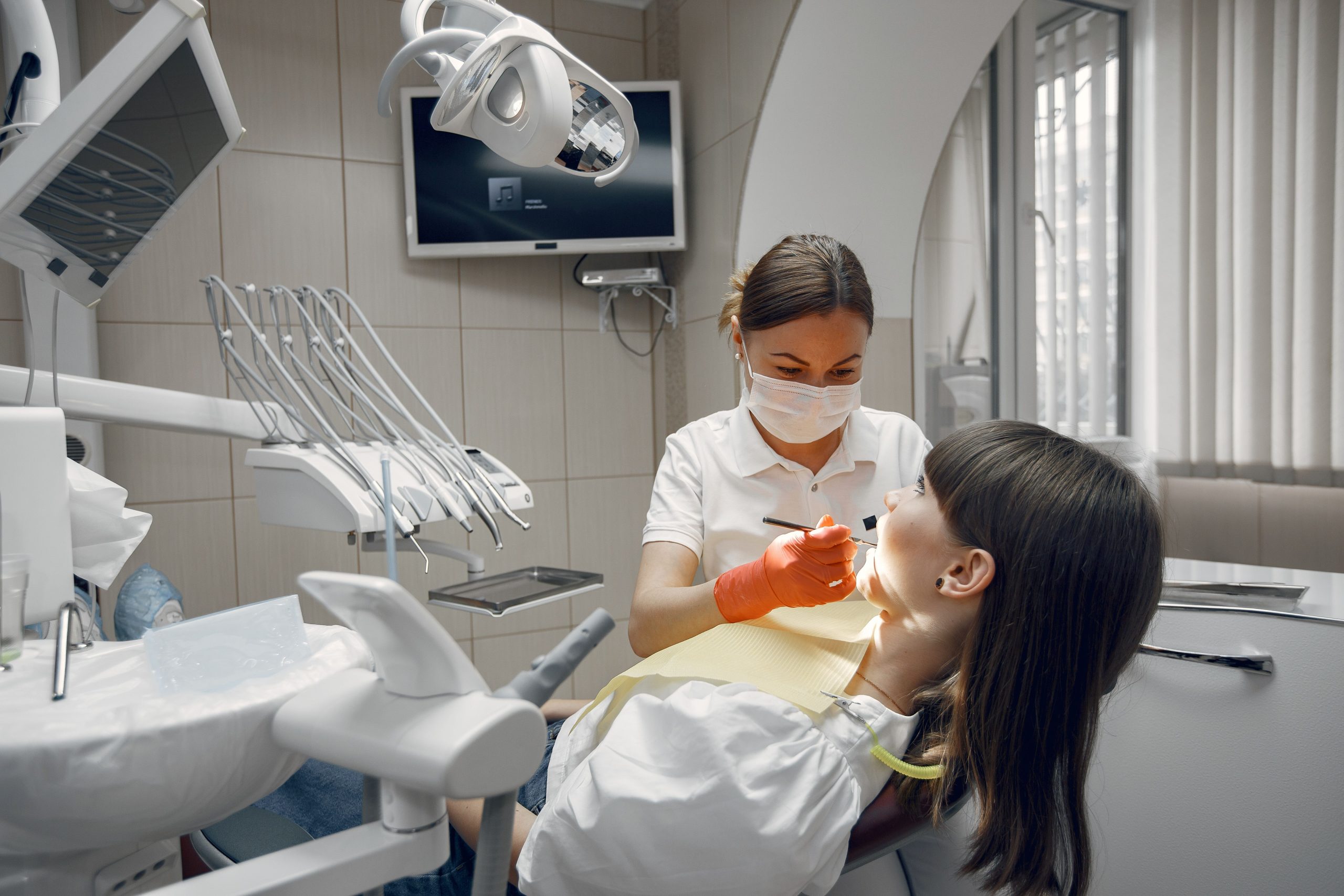 Dentiste effectuant examen dentaire patiente clinique