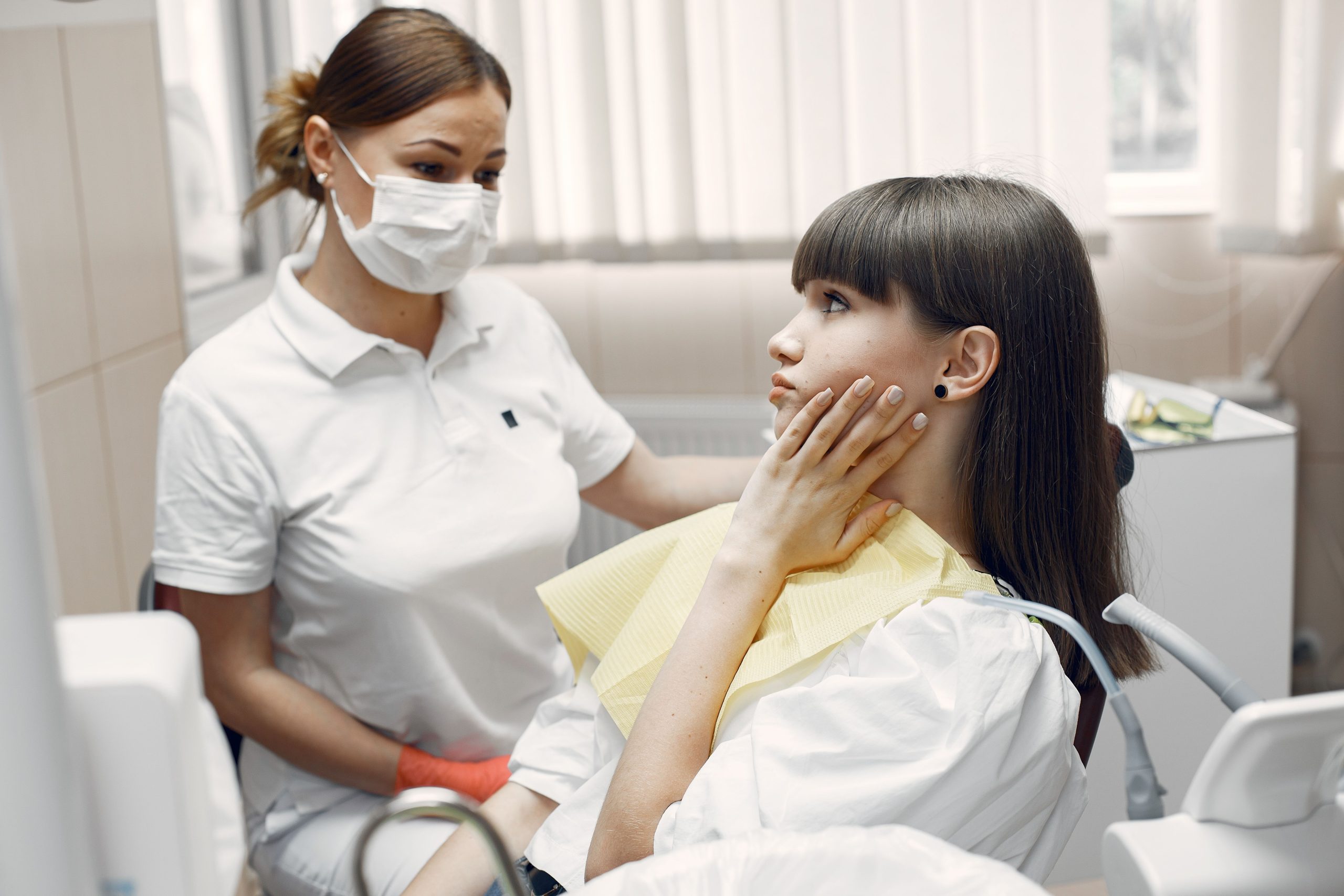 Dentiste examinant jeune femme avec mal dent