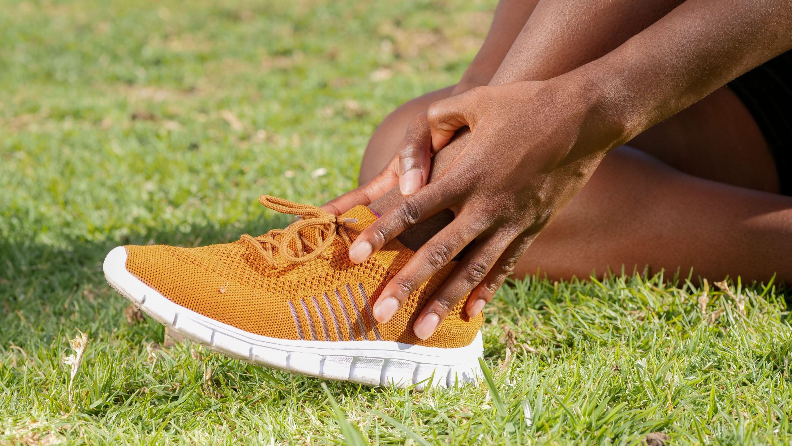 Personne avec douleur à la cheville en baskets oranges