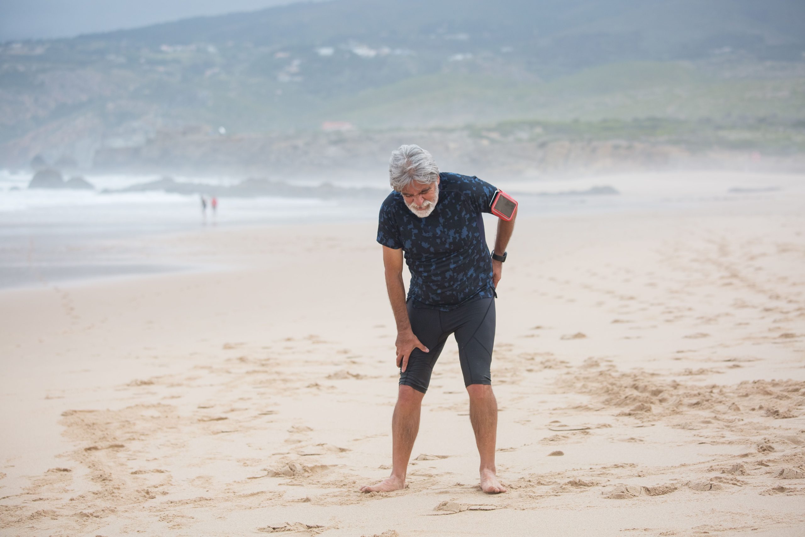 Homme âgé s'étirant plage pour santé