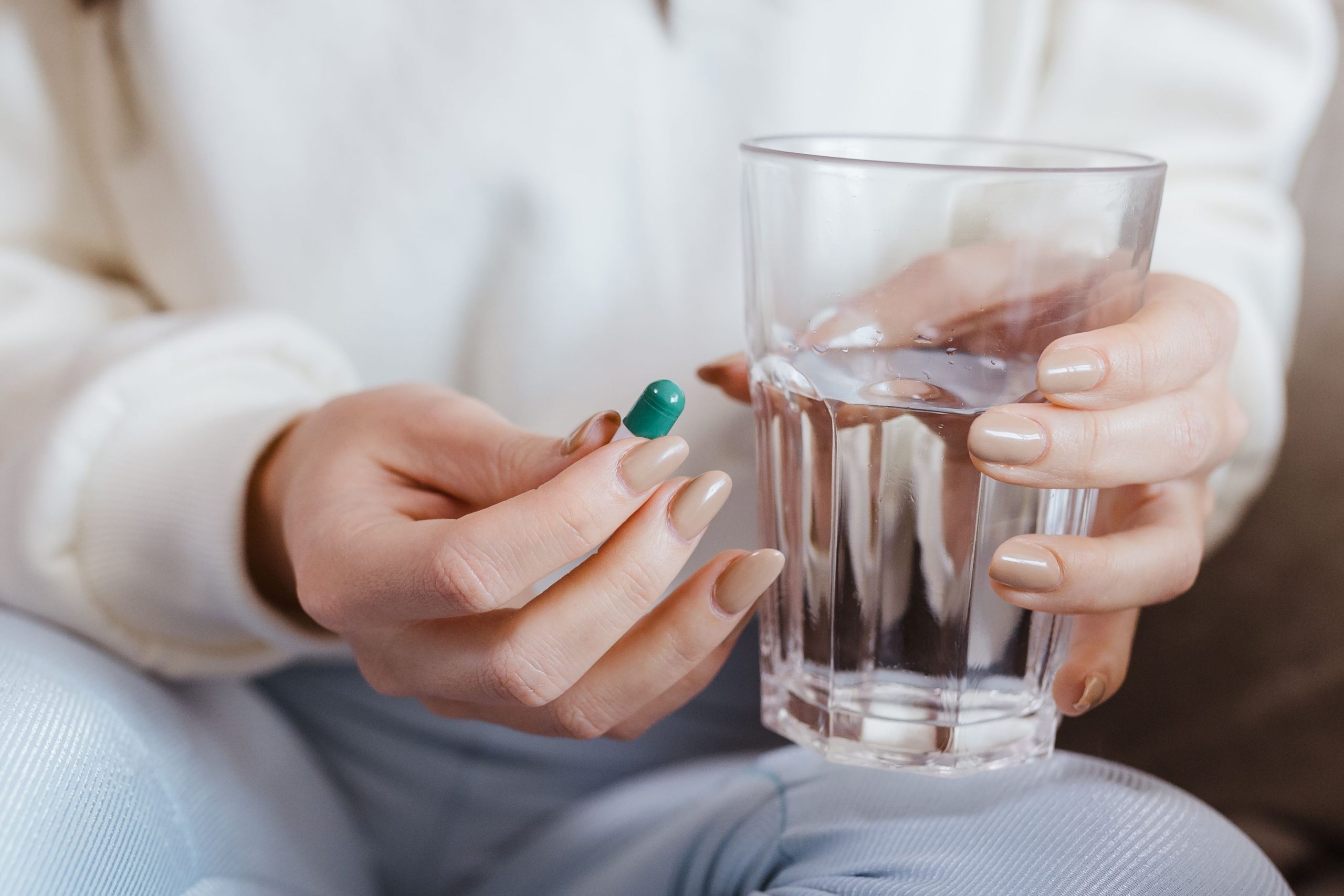 Femme tenant un comprime et verre d'eau