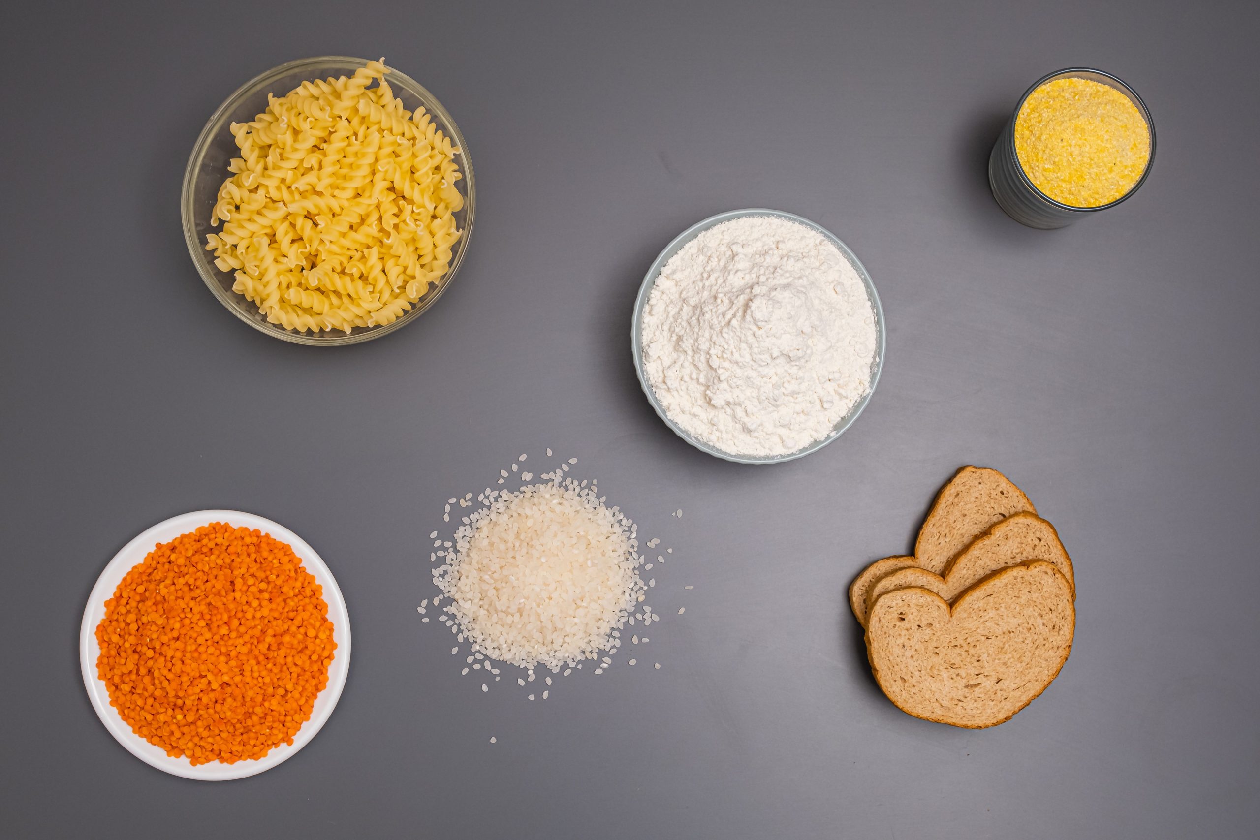 Pâtes, riz et pain sur fond gris