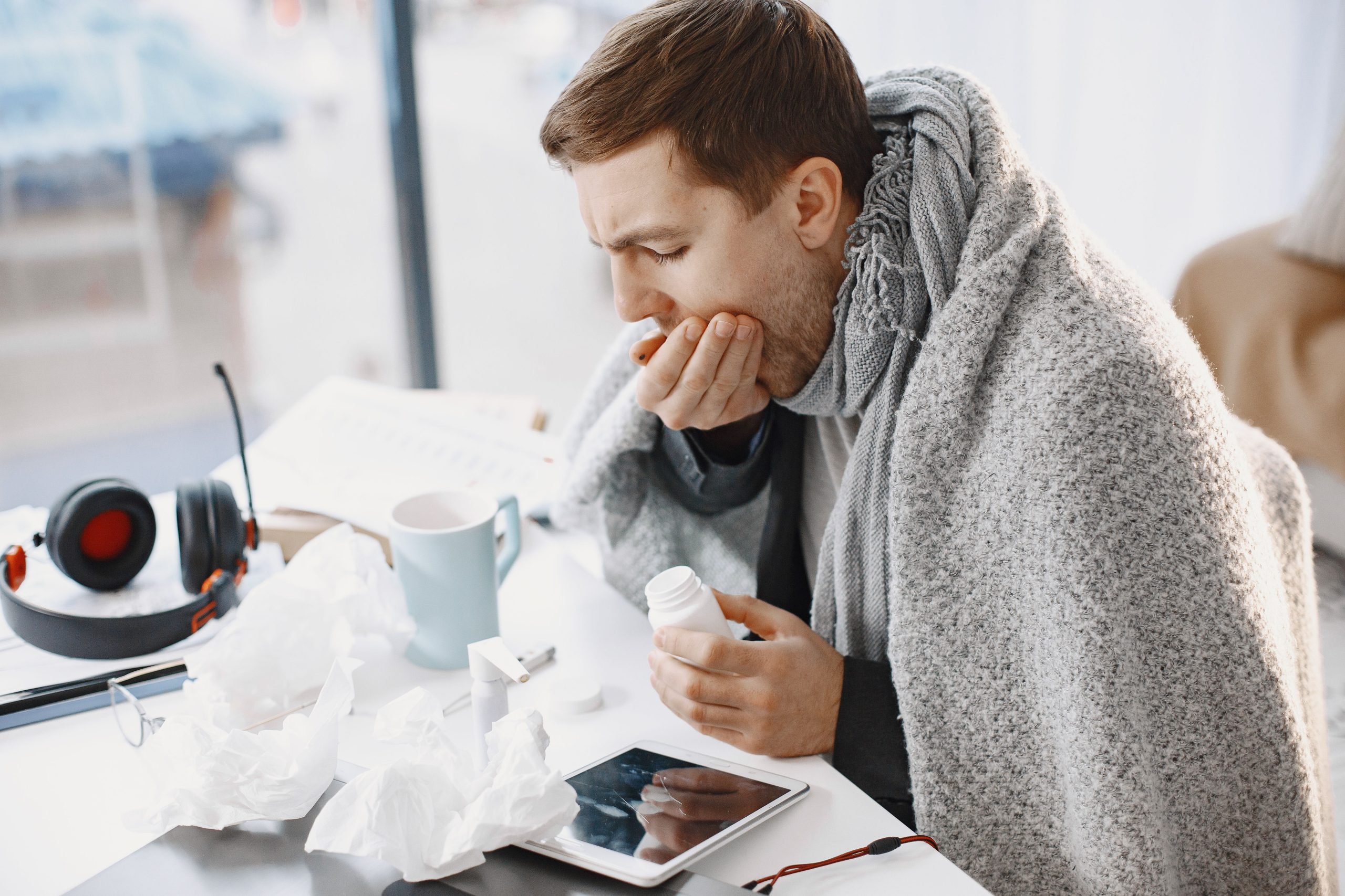 Homme enroule dans couverture avec medicaments