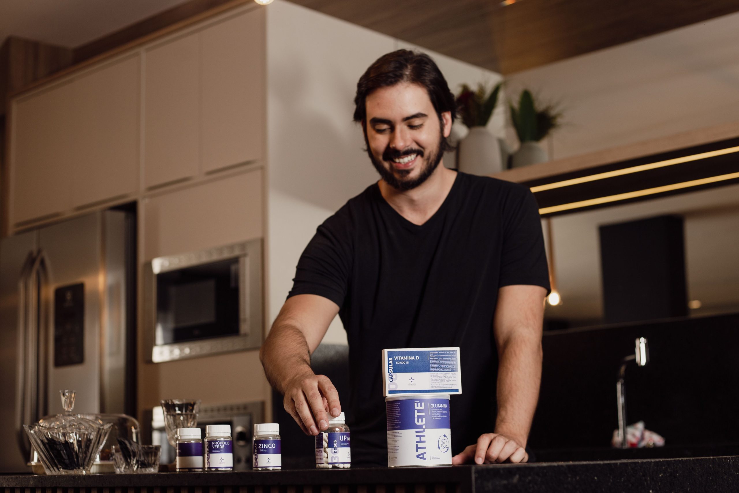 Homme souriant arrangeant supplements vitaminiques cuisine