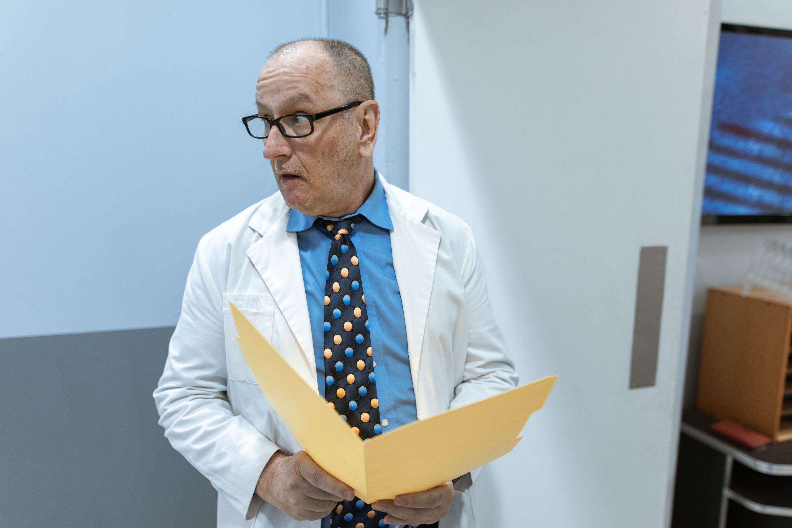 Médecin senior examinant un dossier dans un couloir