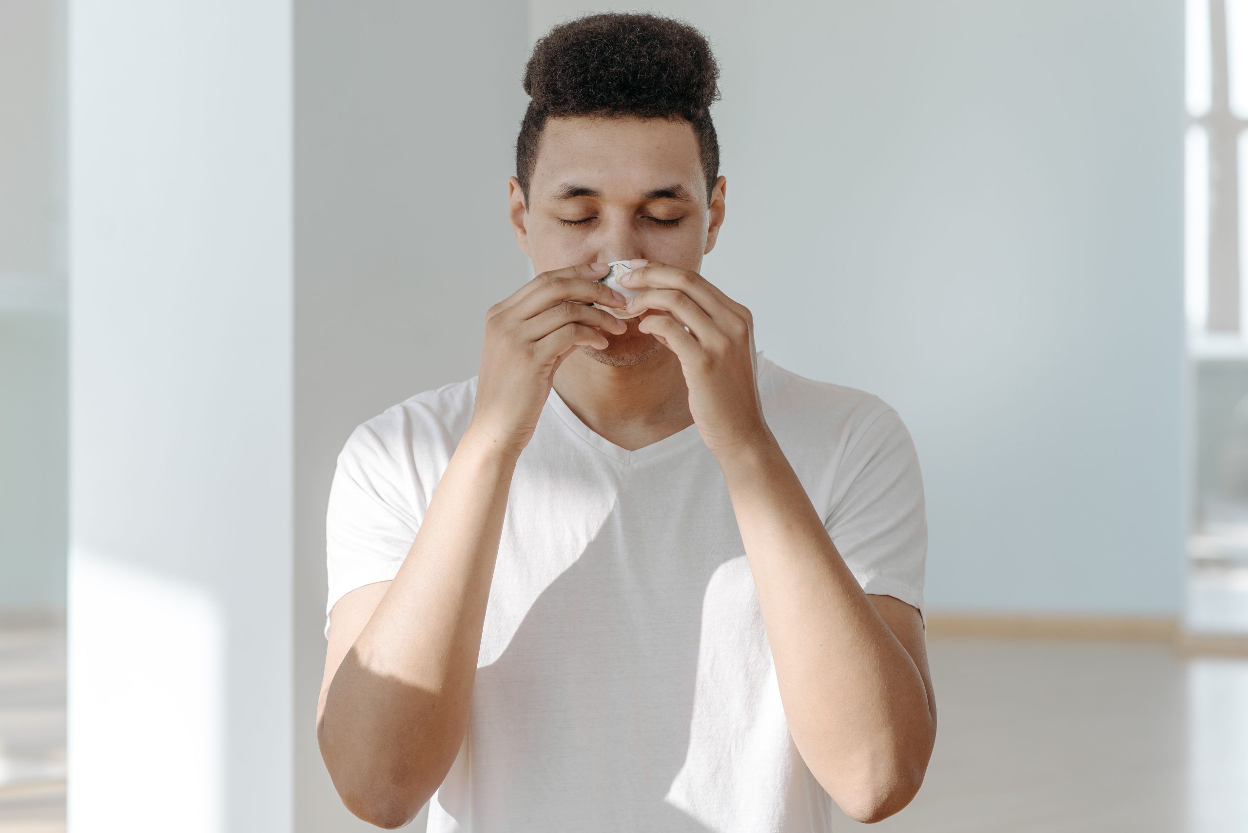 Homme eternuant dans un mouchoir allergie