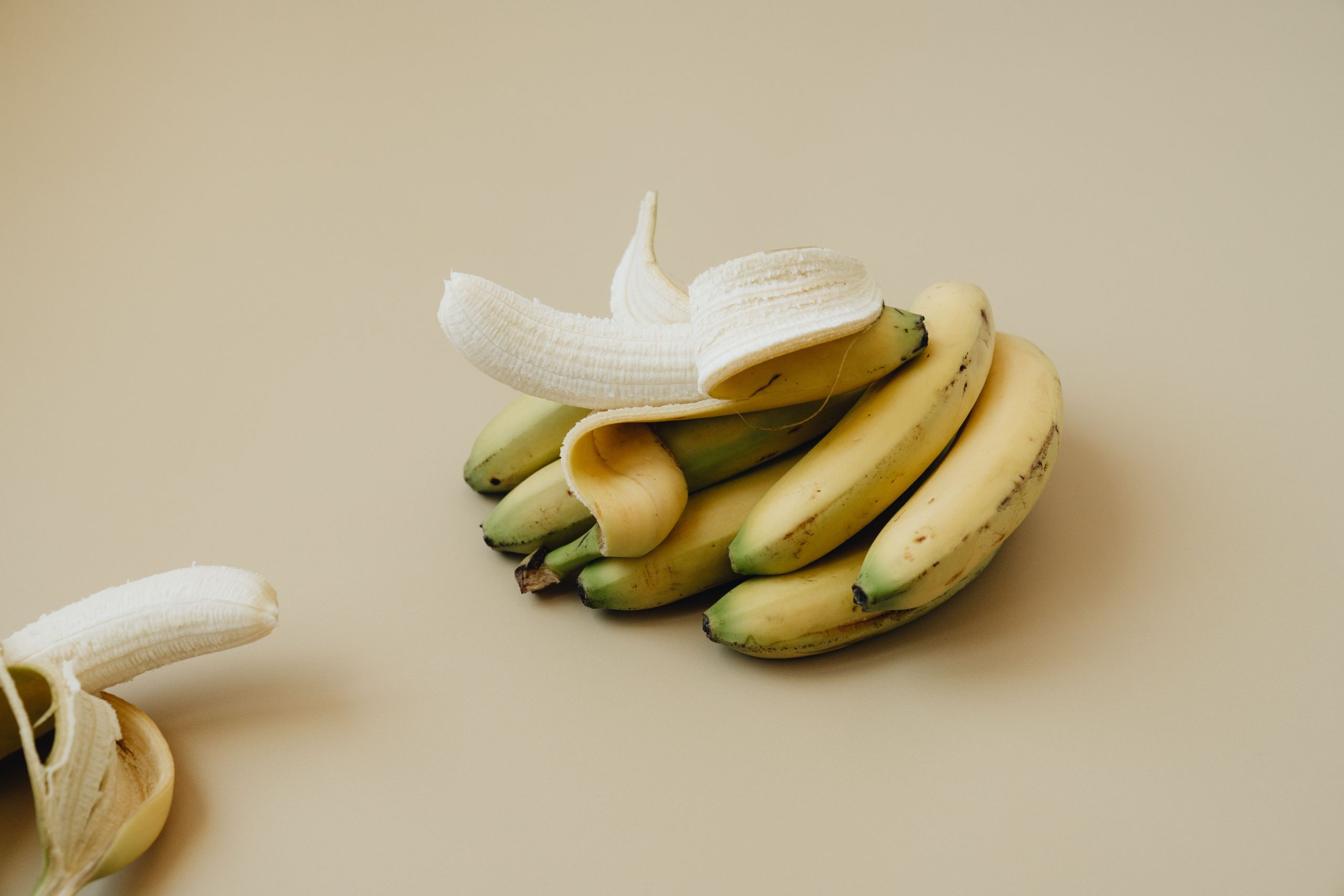 Bananes entières et pelées côte à côte