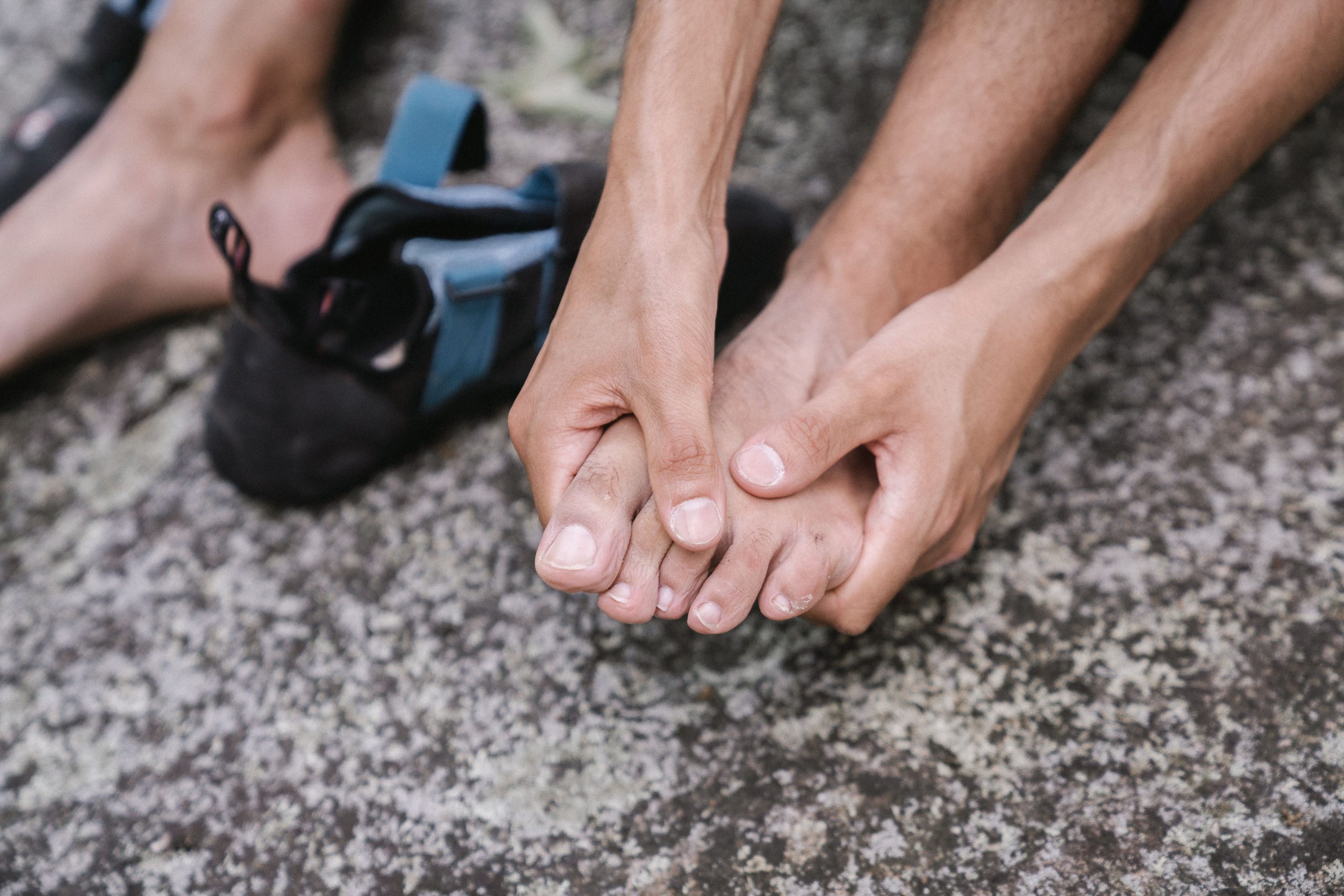 Personne massant ses pieds nus en détente extérieure